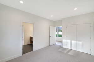 Unfurnished bedroom with light carpet, a closet, and recessed lighting