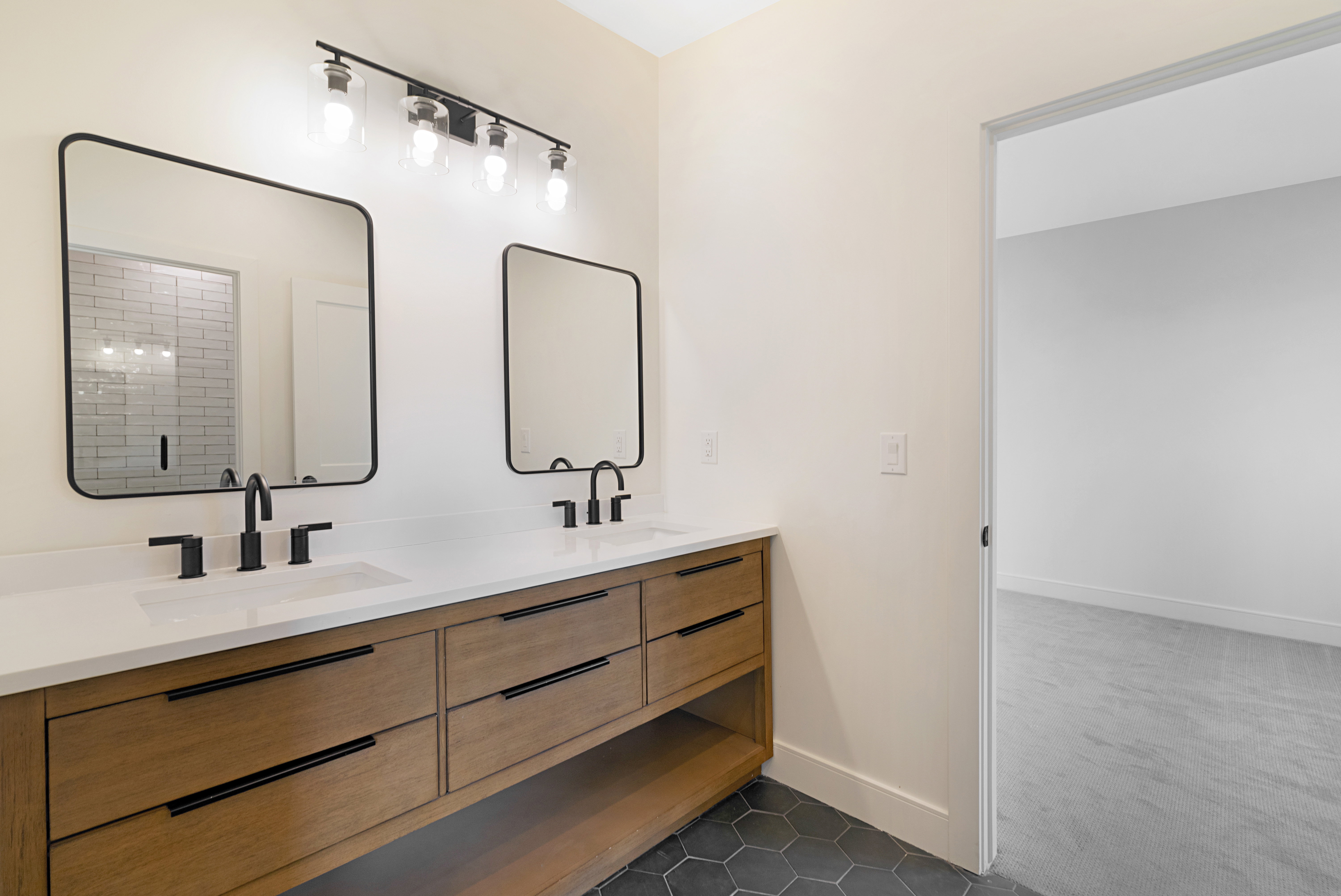 Full bathroom featuring double vanity, dark tile patterned flooring, and dark carpet