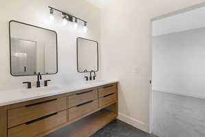 Full bathroom featuring double vanity, dark tile patterned flooring, and dark carpet
