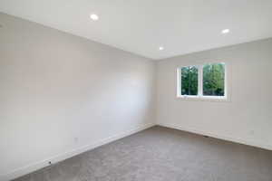 Spare room featuring light carpet and recessed lighting