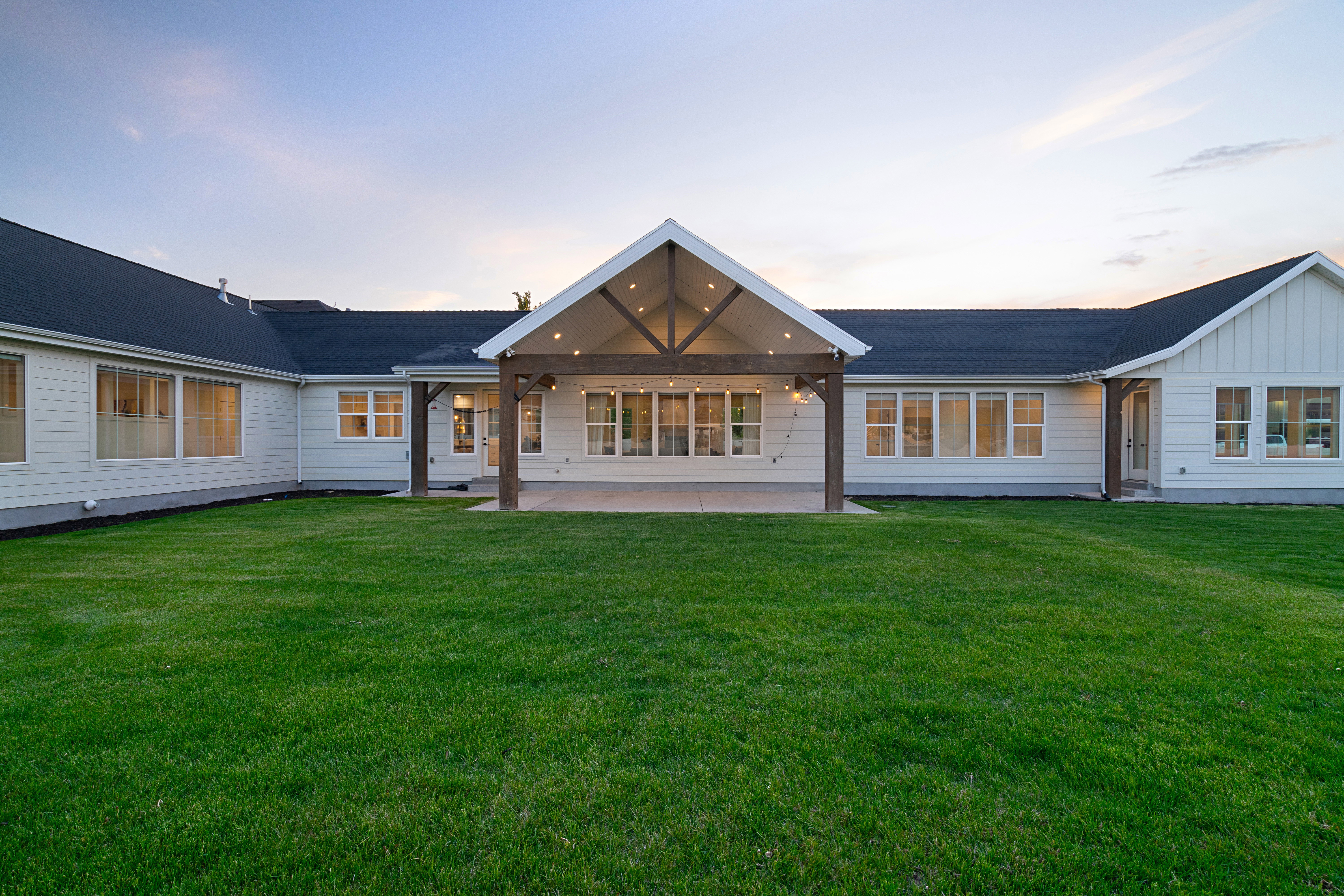 Back of house featuring a patio area, board and batten siding, and a lawn