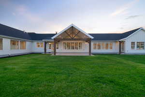 Back of house featuring a patio area, board and batten siding, and a lawn