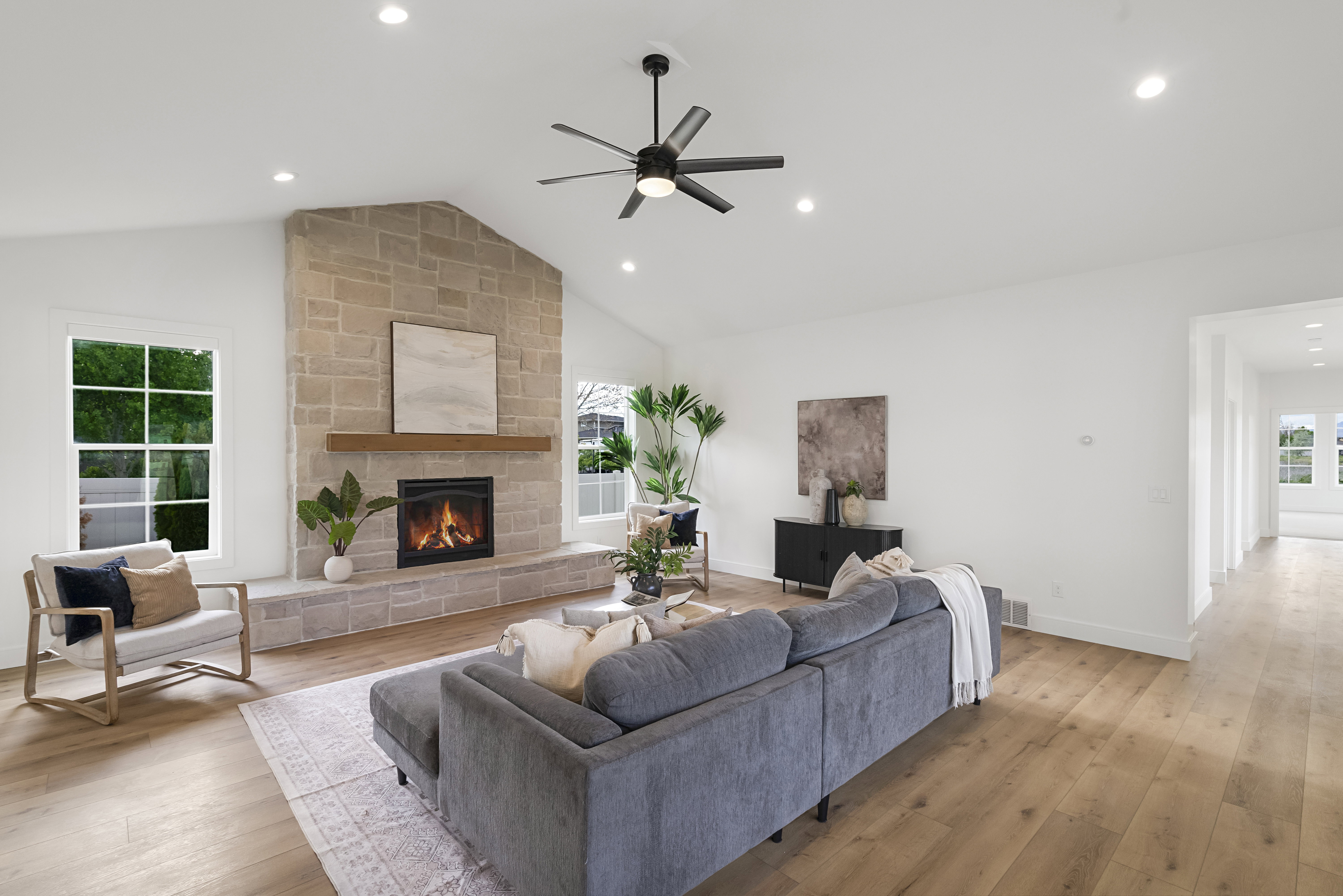 Living area featuring light wood-style floors, healthy amount of natural light, a ceiling fan, a fireplace, and recessed lighting