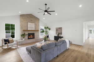 Living area featuring light wood-style floors, healthy amount of natural light, a ceiling fan, a fireplace, and recessed lighting