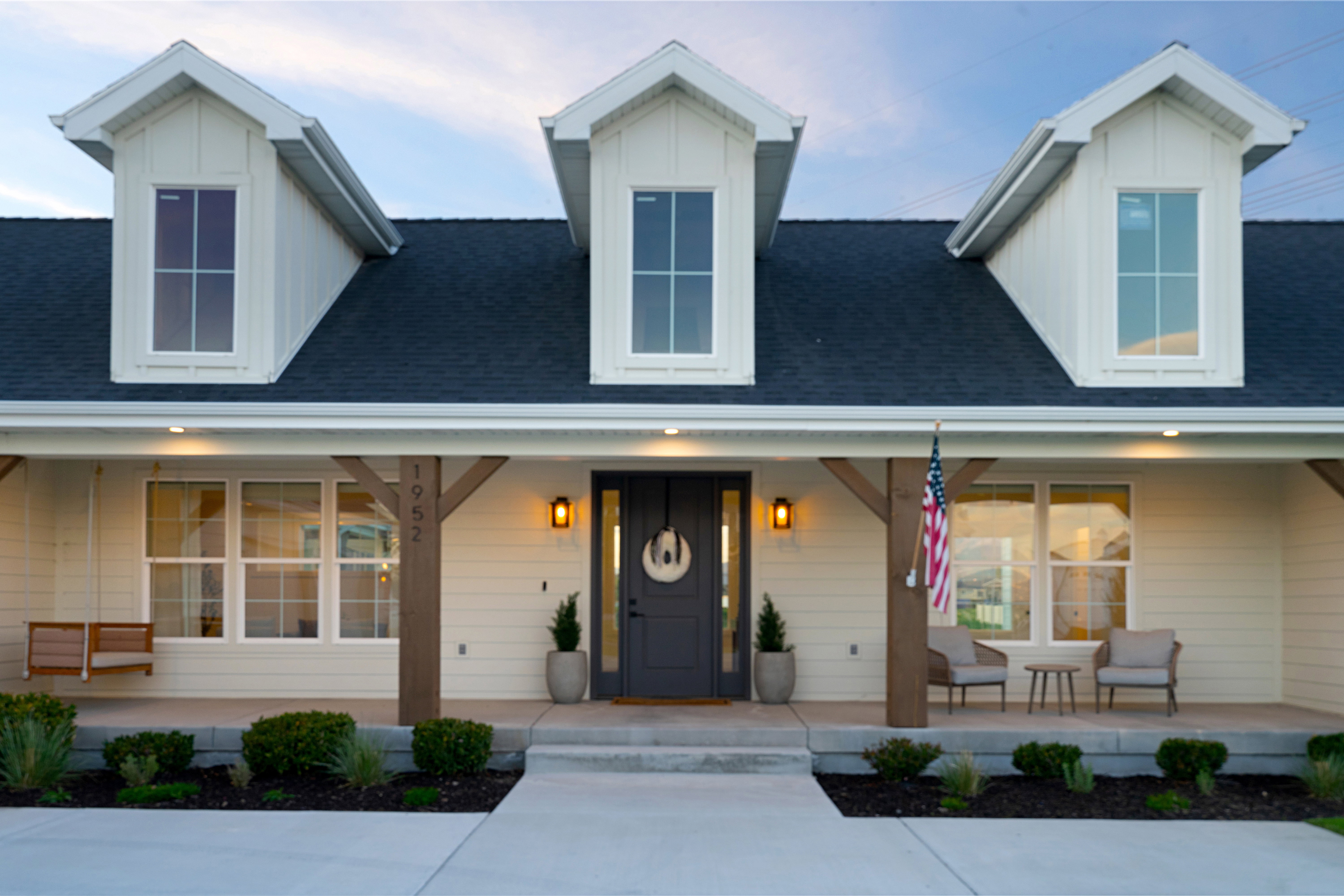 View of front of property with covered porch, a shingled roof, and board and batten siding