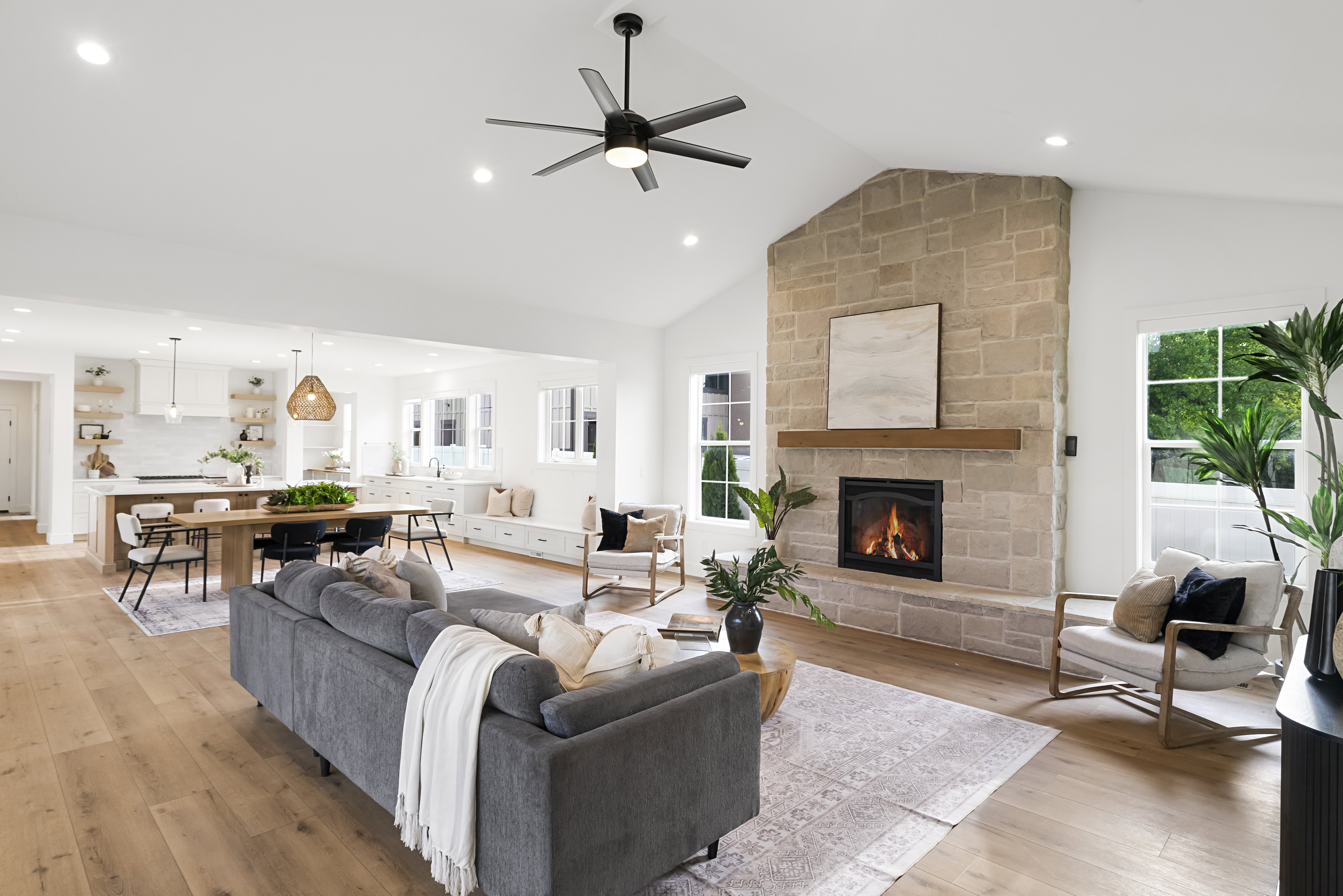 Living room featuring ceiling fan, a fireplace, light wood-type flooring, recessed lighting, and vaulted ceiling