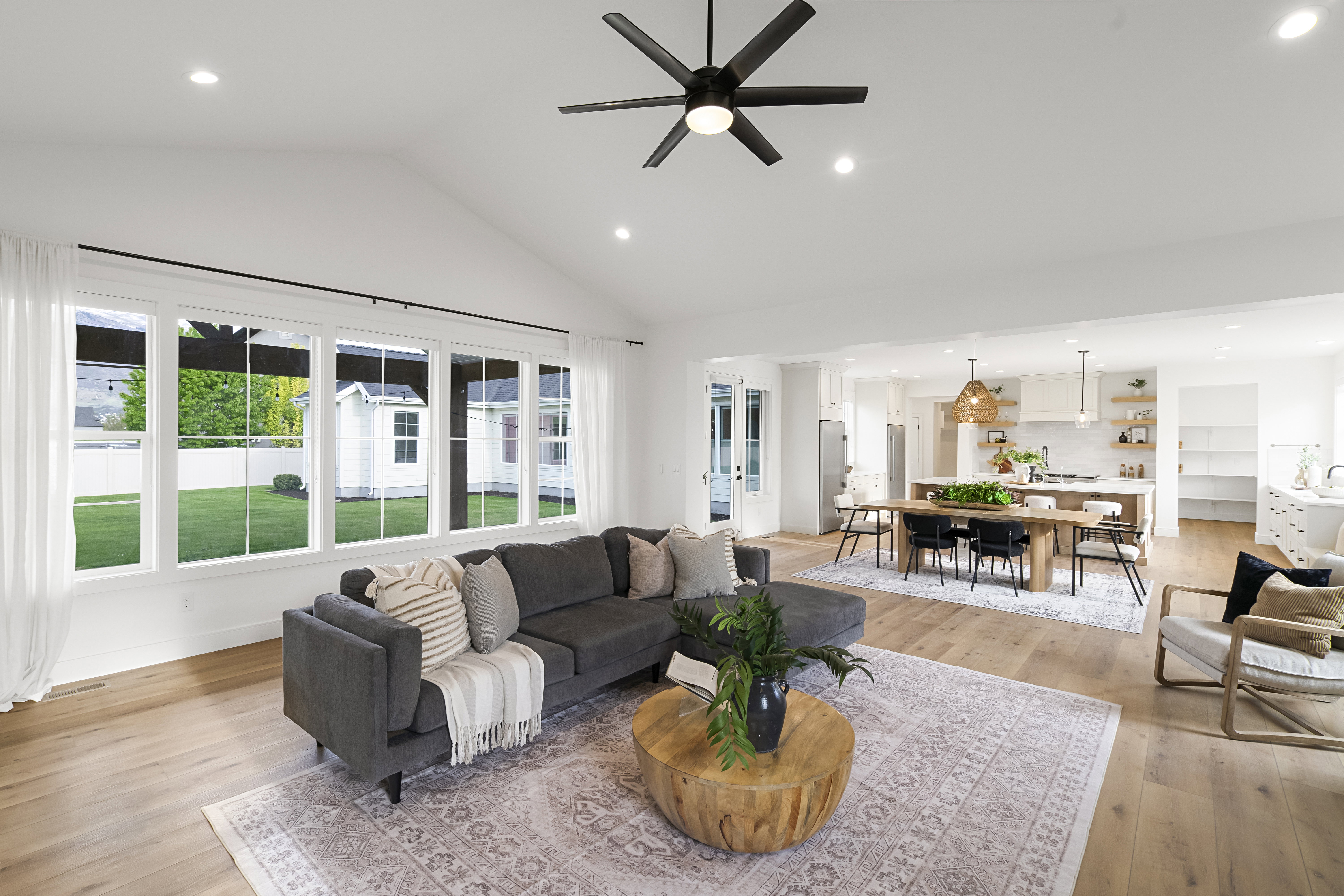 Living area featuring recessed lighting, light wood-style floors, ceiling fan, and vaulted ceiling