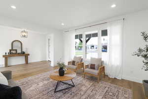 Living area with light wood-type flooring and recessed lighting