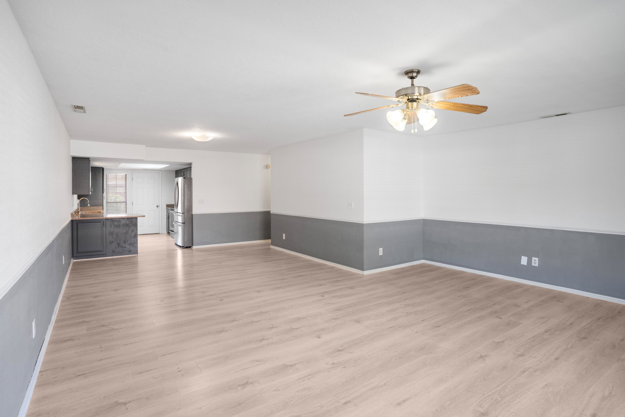 Unfurnished living room with light wood-type flooring and ceiling fan