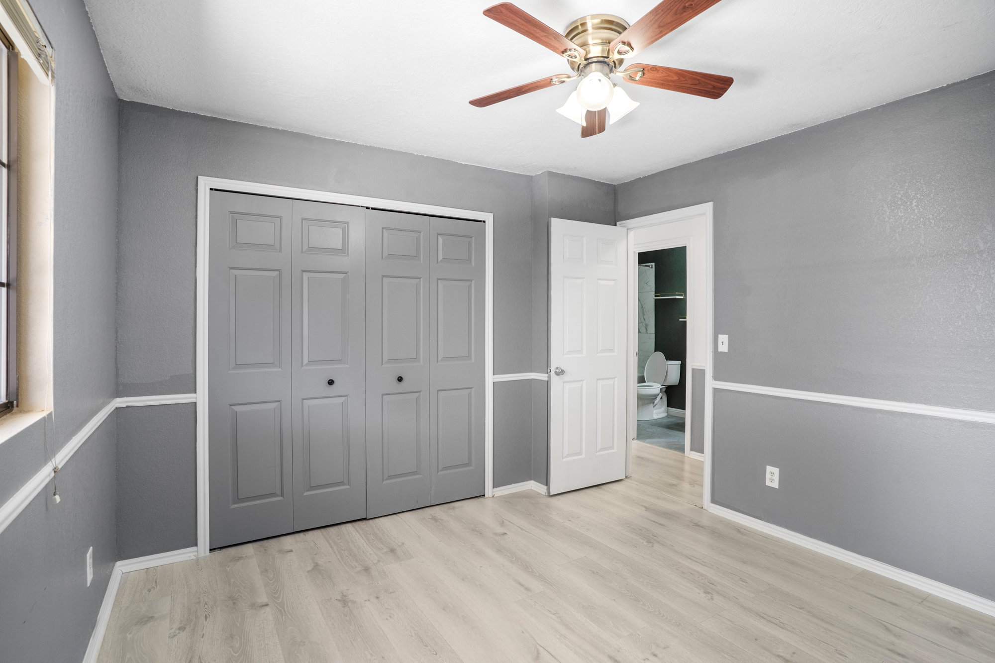 Unfurnished bedroom featuring ceiling fan, light wood-type flooring, and a closet