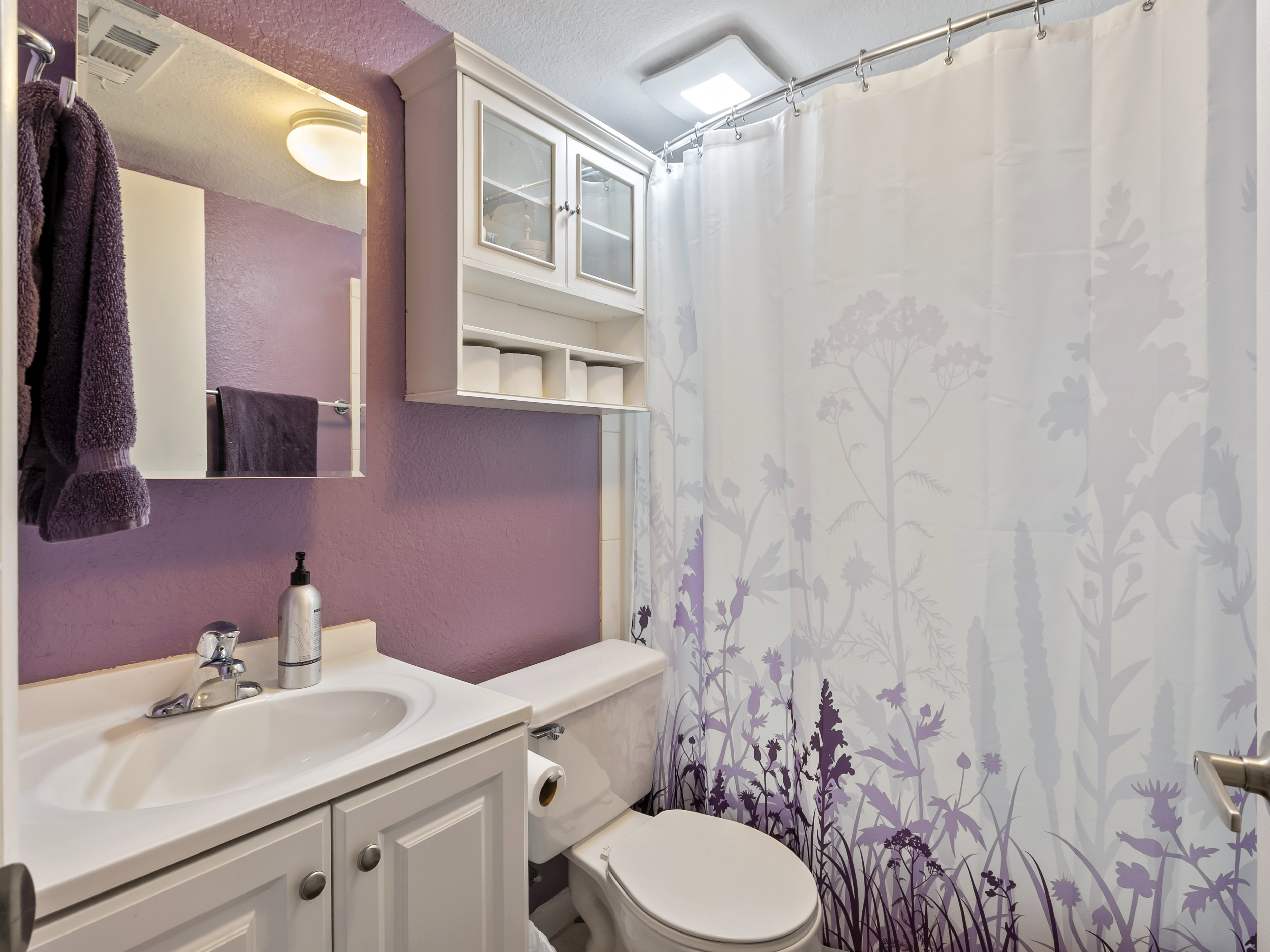 Full bathroom featuring a textured wall, vanity, curtained shower, and a textured ceiling