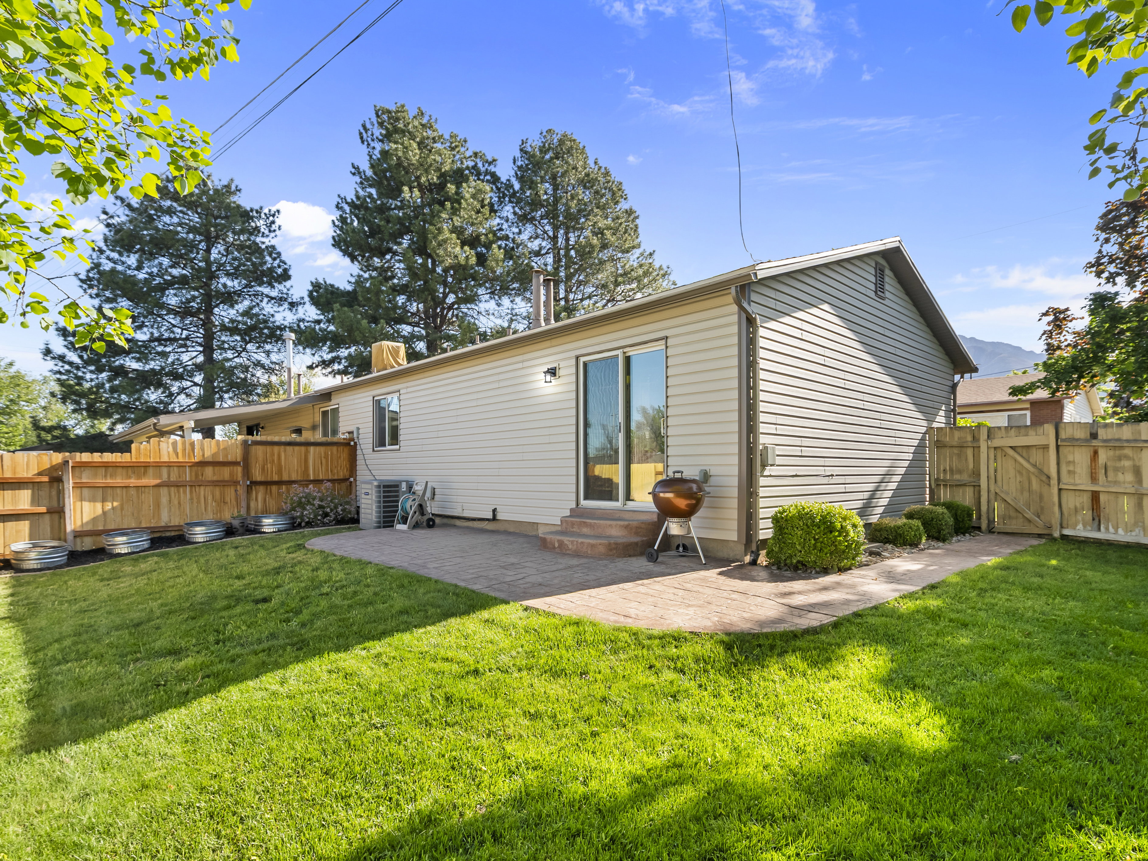 Rear view of house featuring a gate, a fenced backyard, entry steps, and a patio area