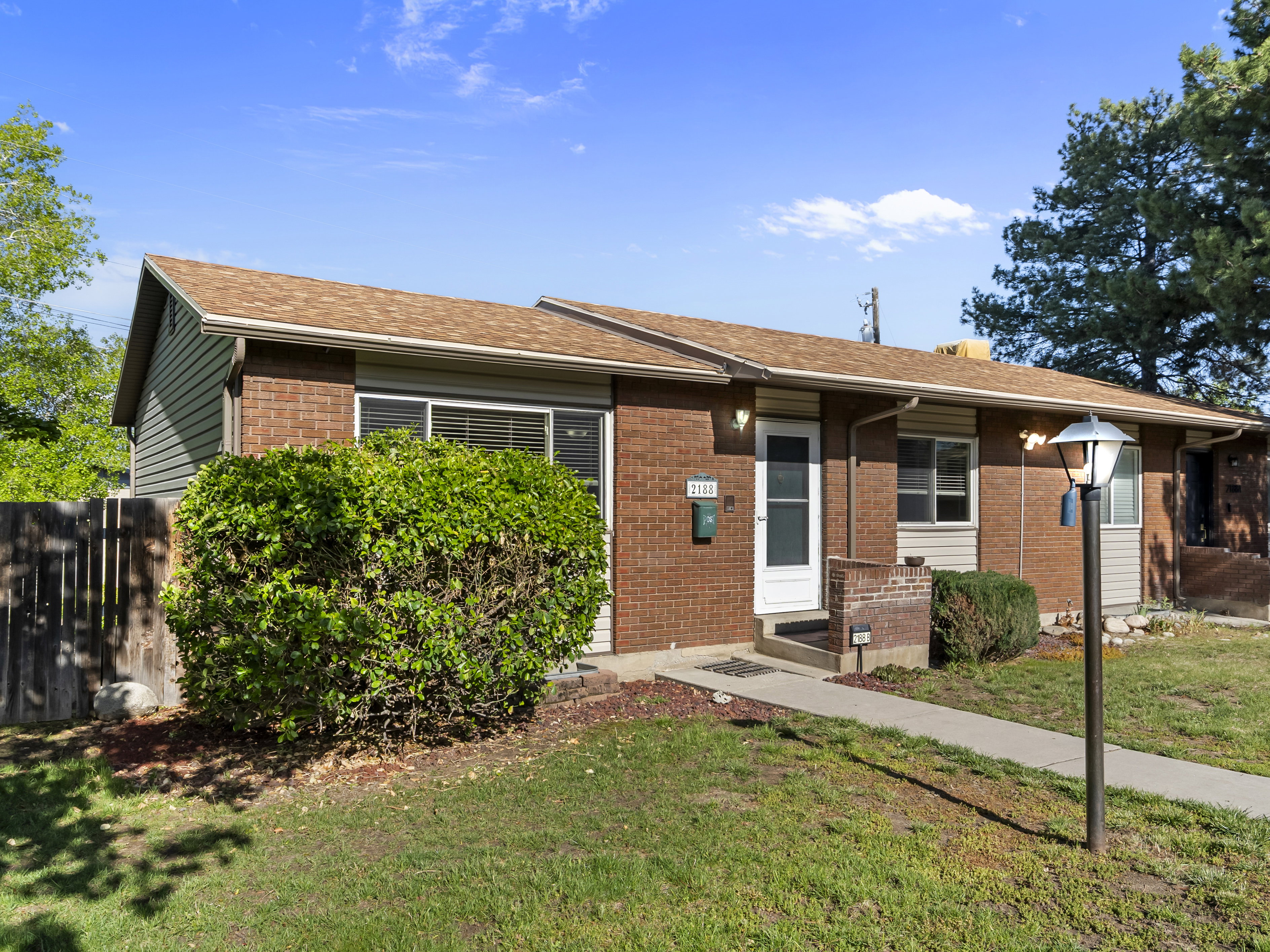 View of front of home with brick siding and a shingled roof
