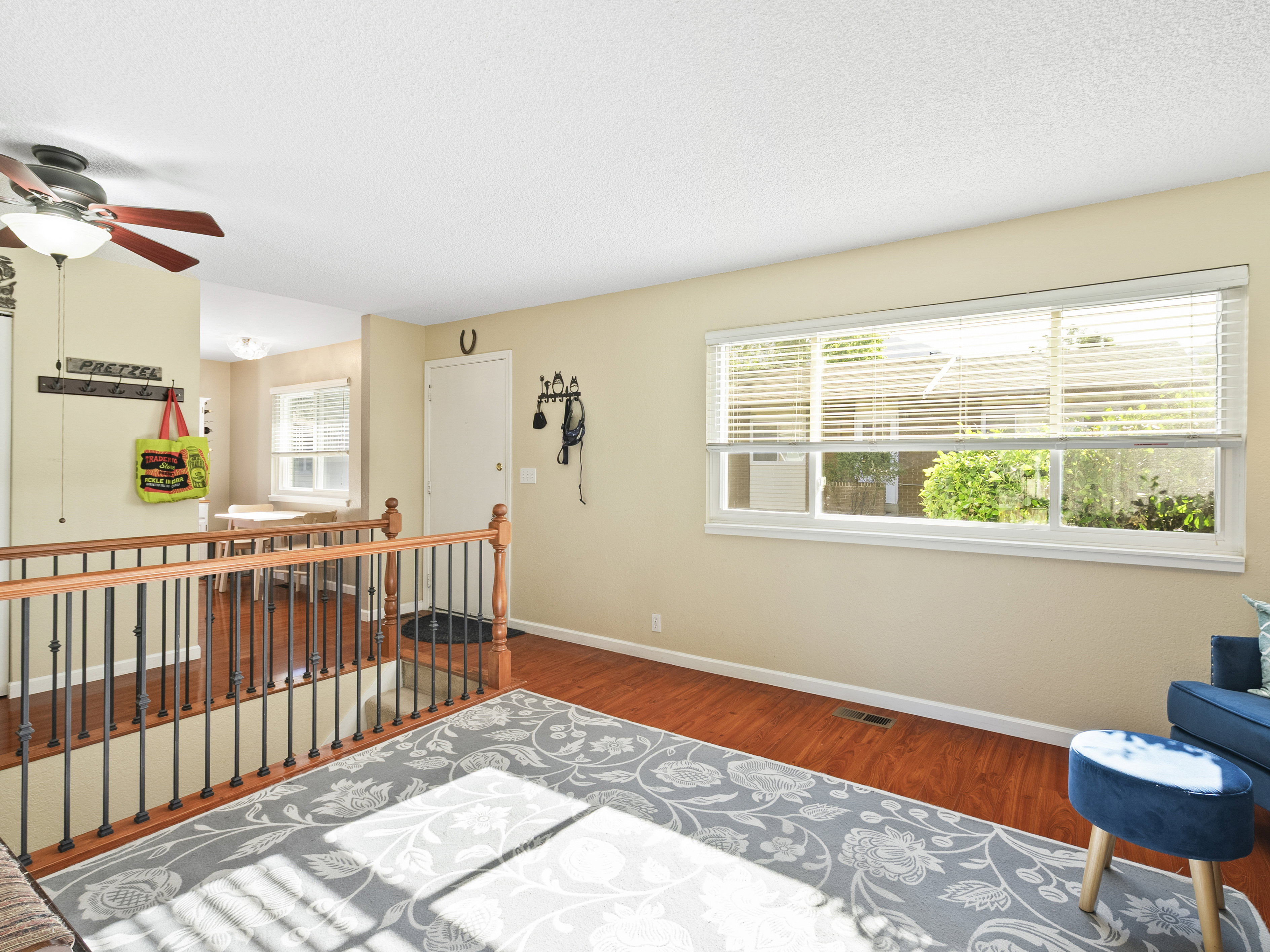 Sitting room featuring wood finished floors, a ceiling fan, a textured ceiling, and an upstairs landing