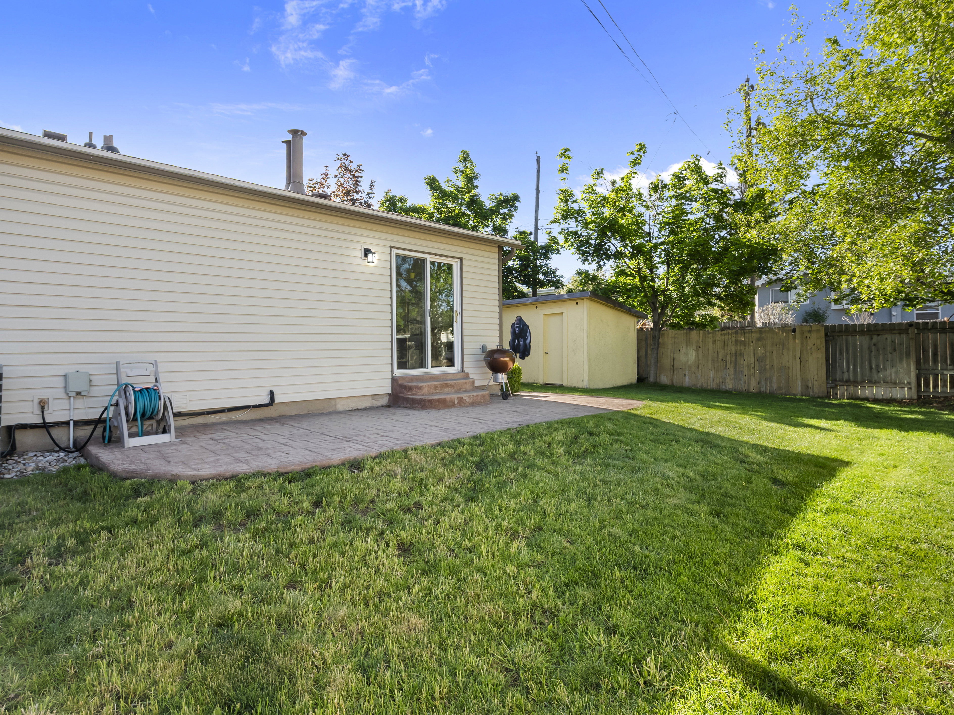 Back of property with a patio area, a fenced backyard, an outbuilding, and entry steps