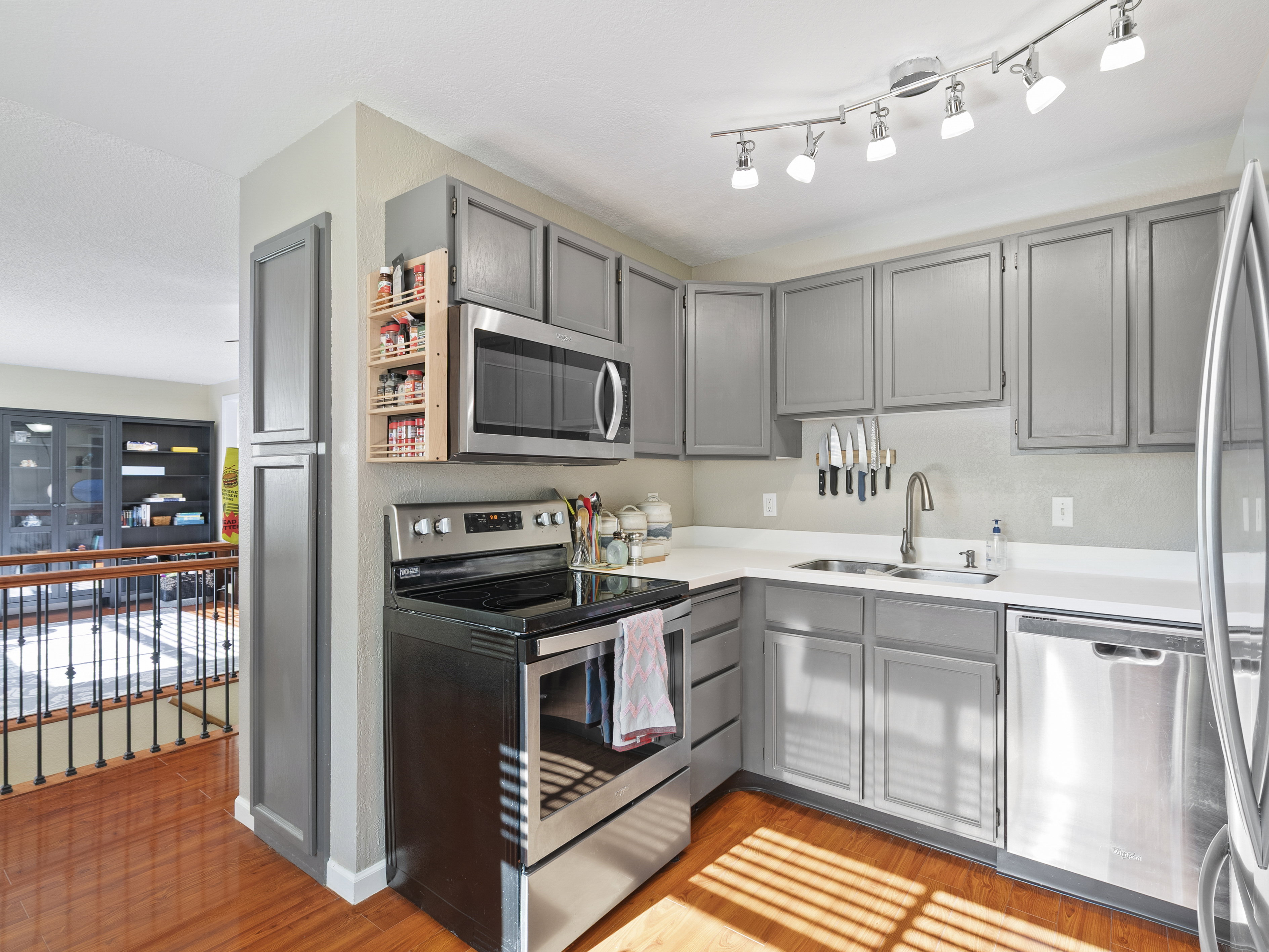 Kitchen featuring gray cabinetry, stainless steel appliances, light countertops, and light wood finished floors
