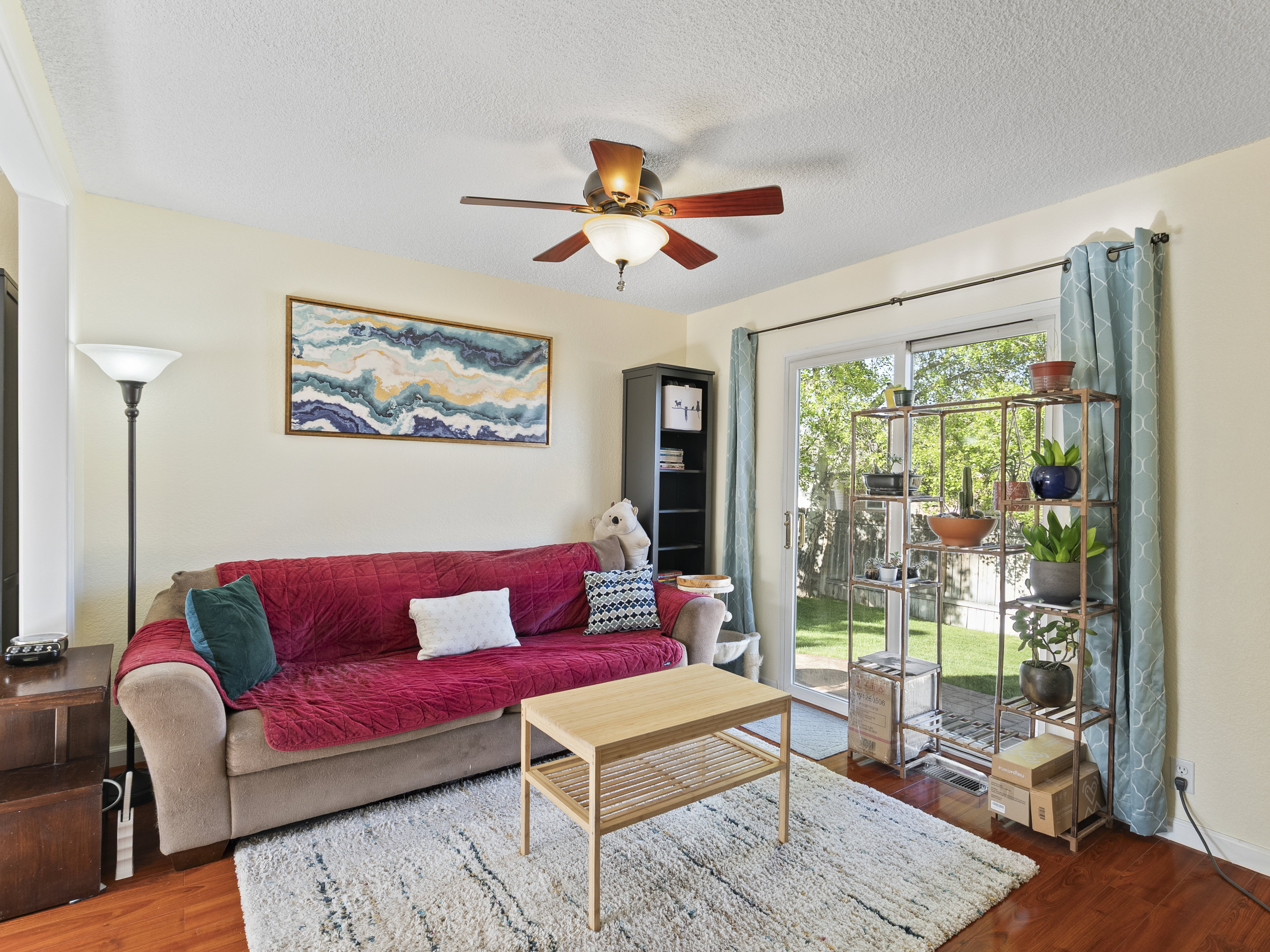 Living room featuring wood finished floors, ceiling fan, and a textured ceiling