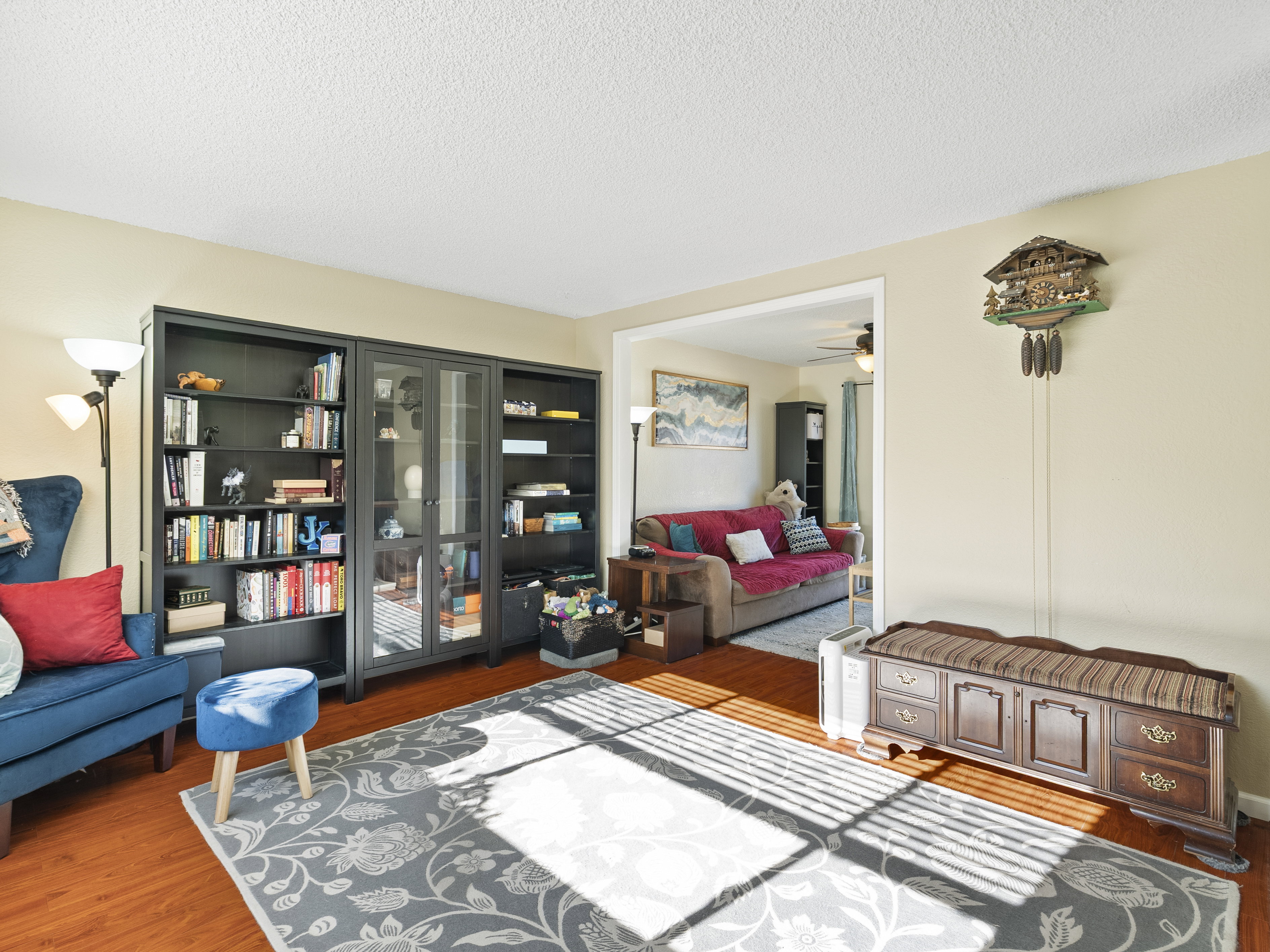 Living area with dark wood finished floors, a ceiling fan, and a textured ceiling