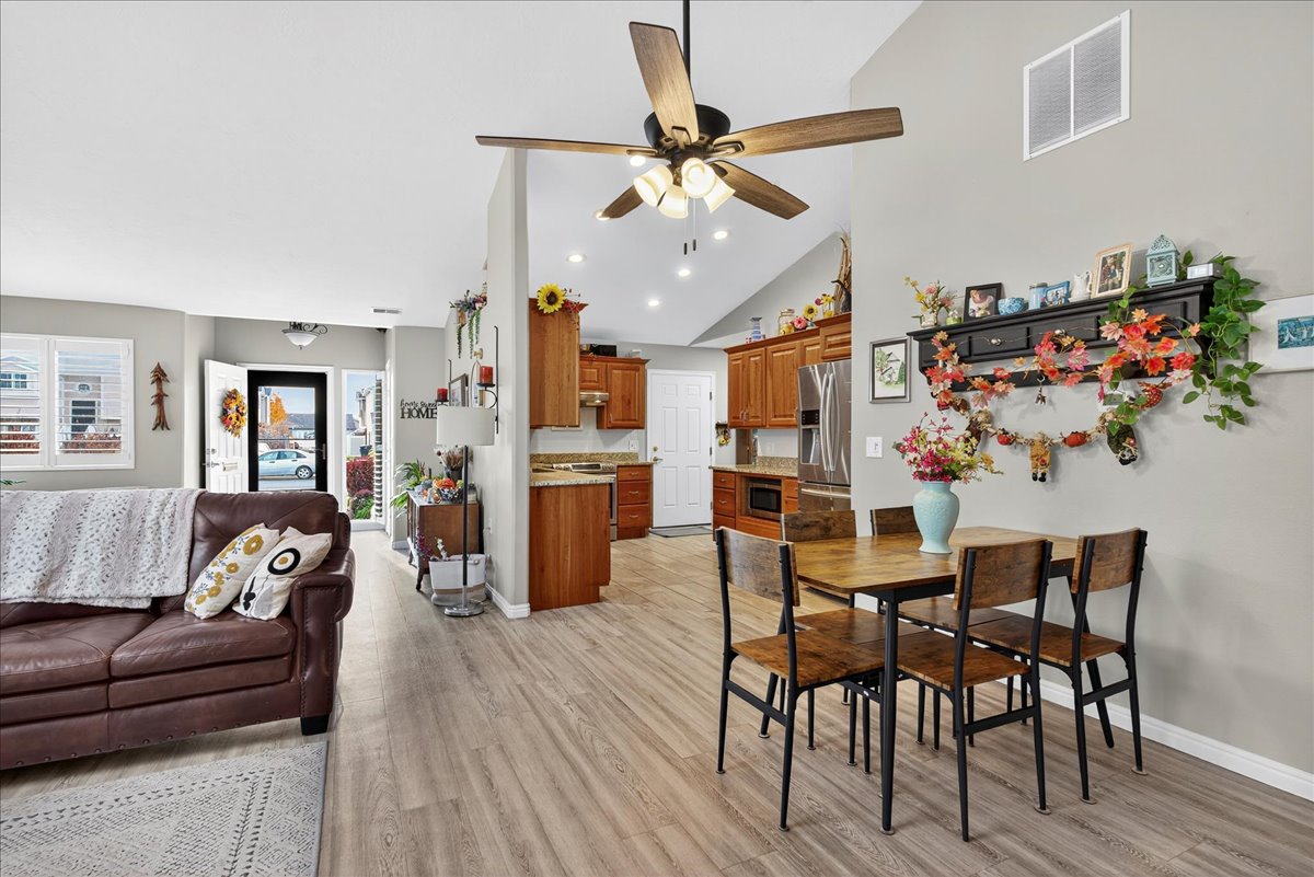 Dining space with light wood-type flooring, lofted ceiling, a ceiling fan, and recessed lighting