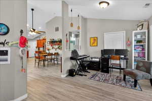 Office with lofted ceiling, ceiling fan, and light wood finished floors