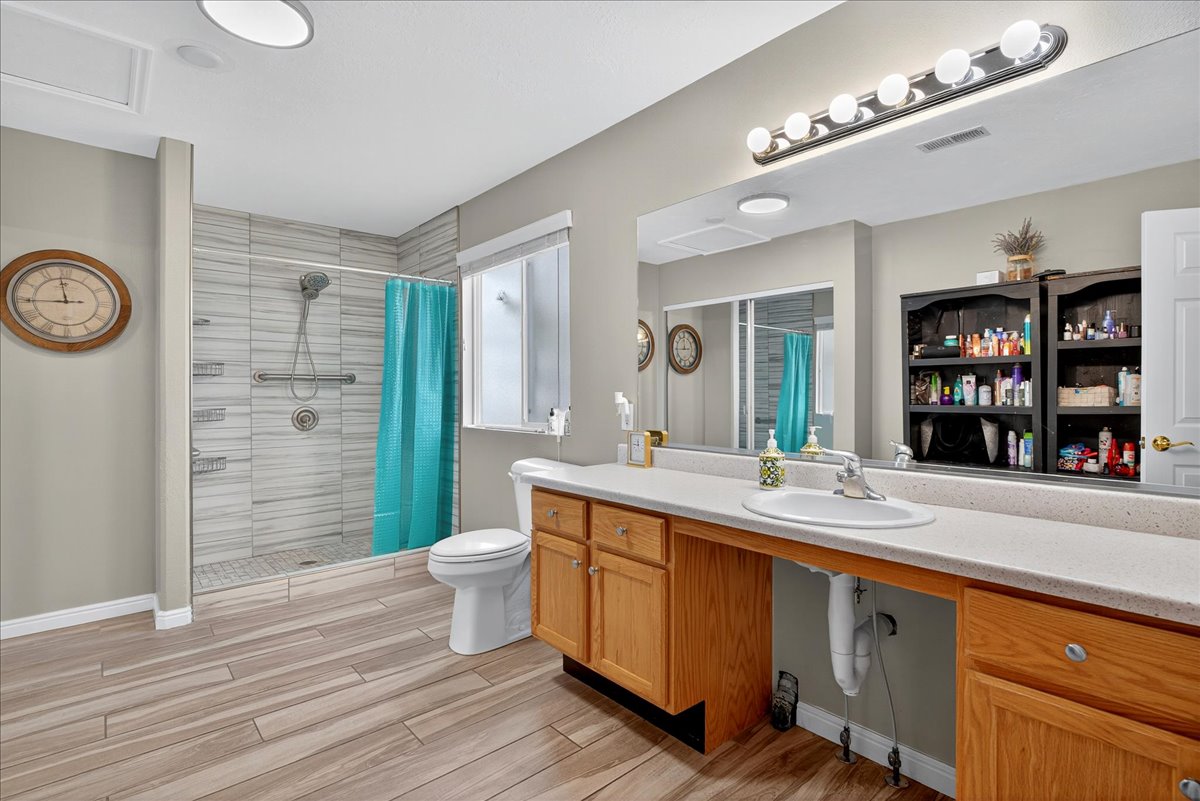 Full bathroom featuring vanity, a stall shower, and wood tiled floors