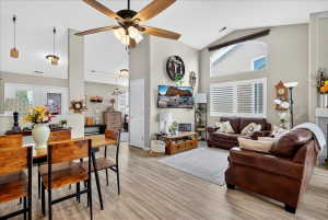 Living room featuring lofted ceiling, plenty of natural light, light wood-style flooring, and a ceiling fan