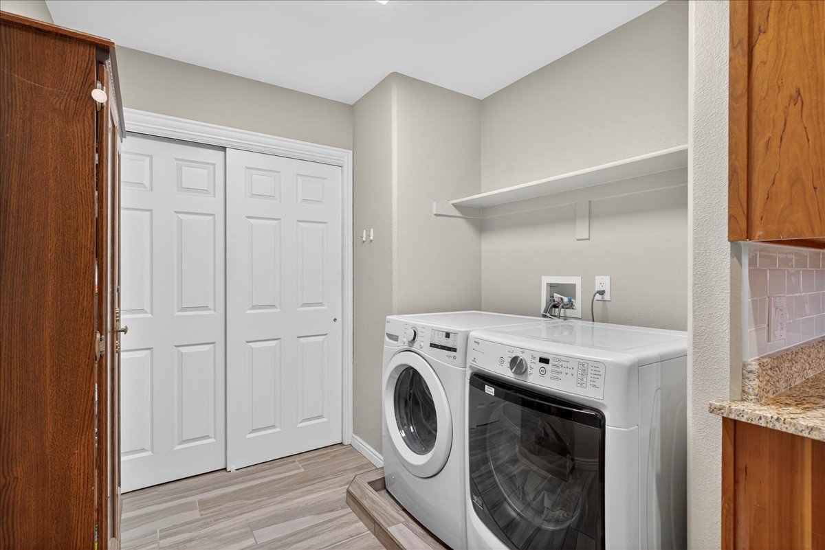 Laundry area featuring independent washer and dryer and light wood finished floors
