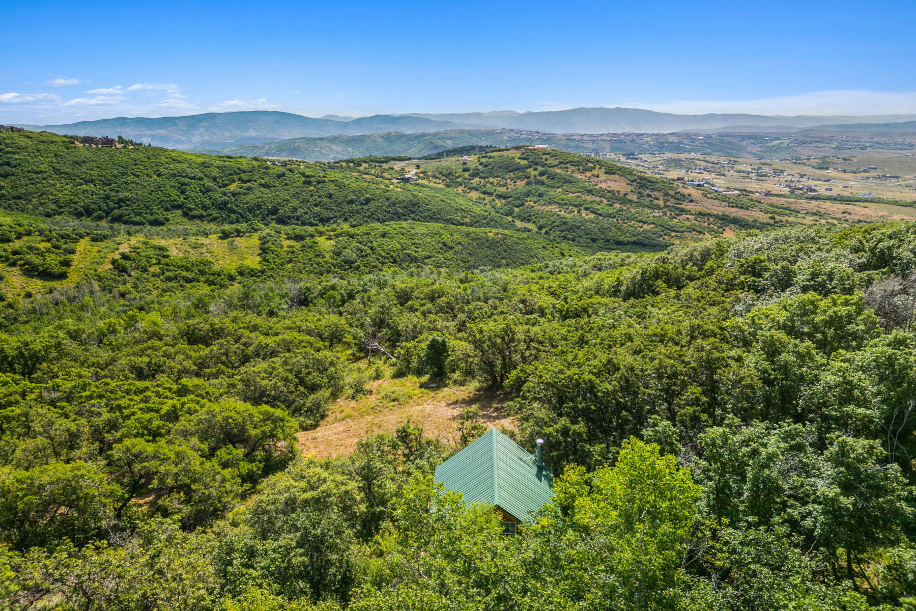 Aerial view of a mountain backdrop and a heavily wooded area