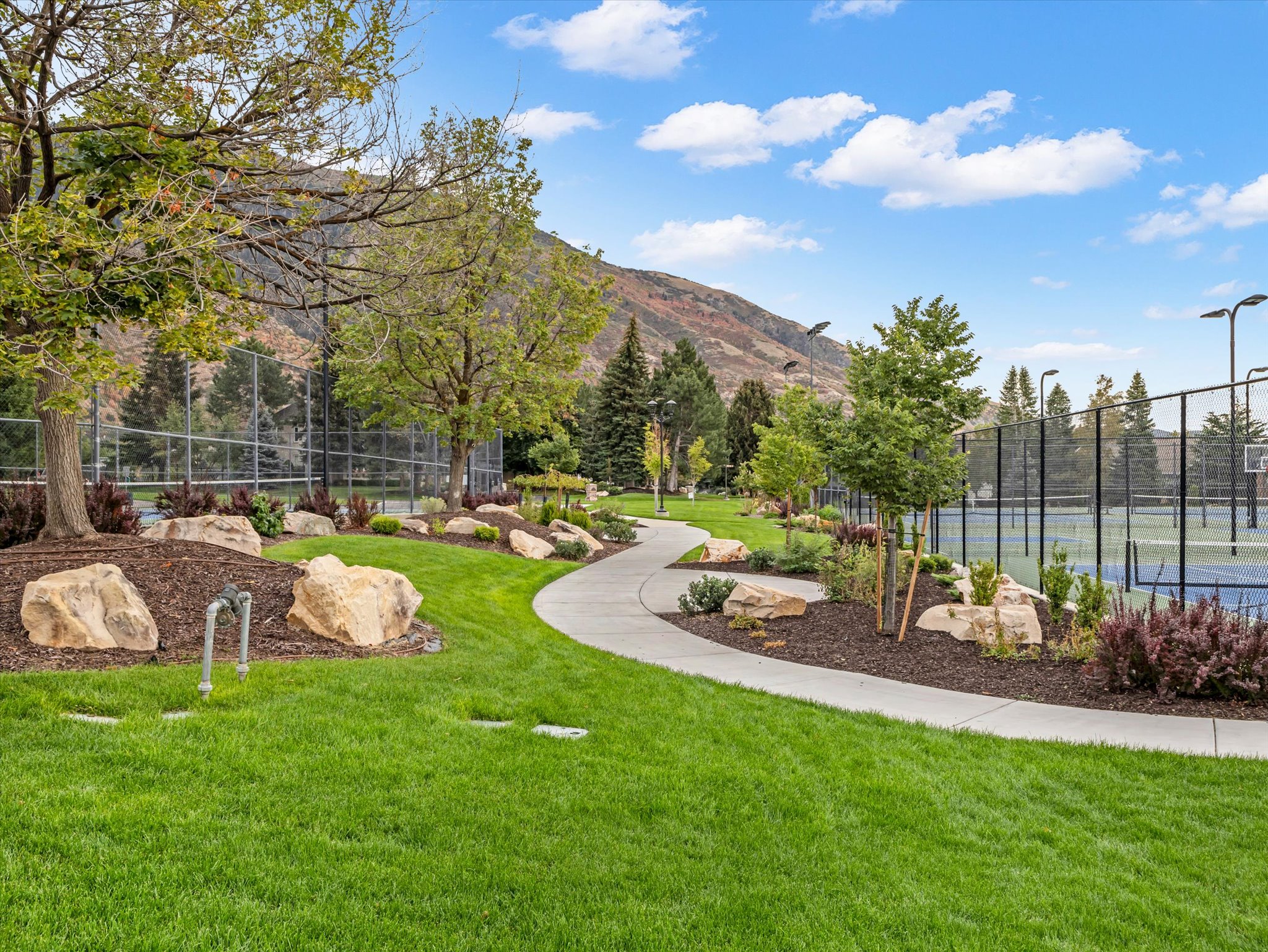 Curved concrete pathway winding through landscaped grounds