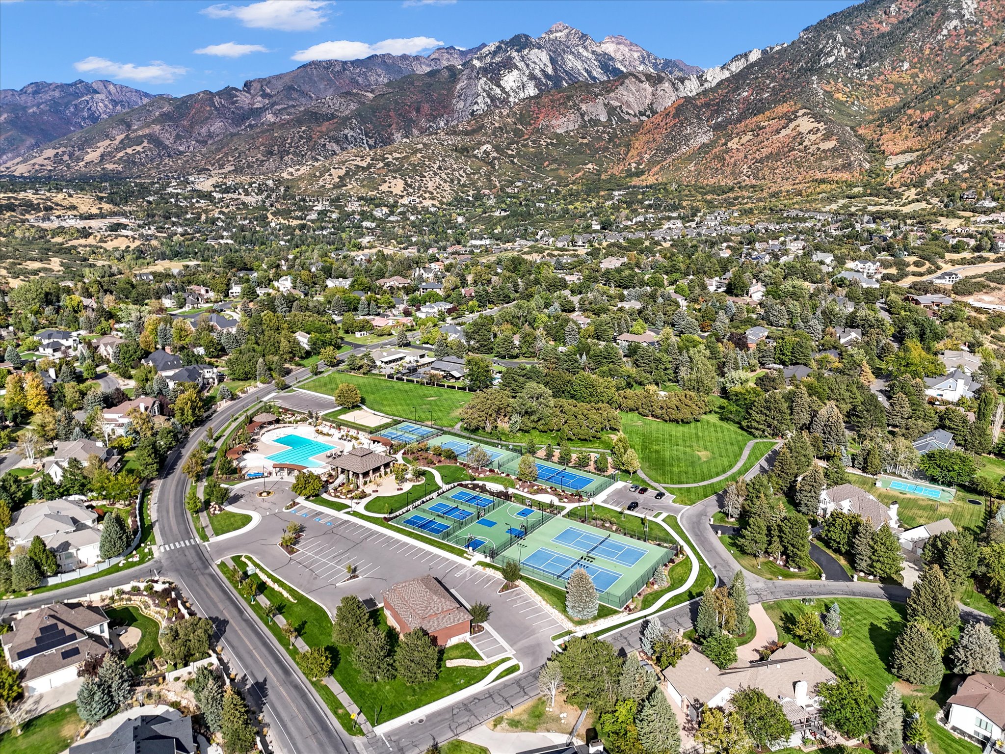 Aerial perspective showcasing community amenities including multiple tennis courts, a swimming pool, and a recreational building