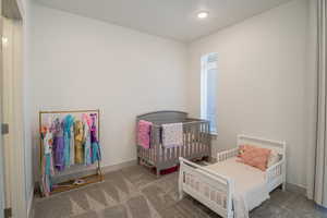 Bedroom featuring carpet floors and a crib