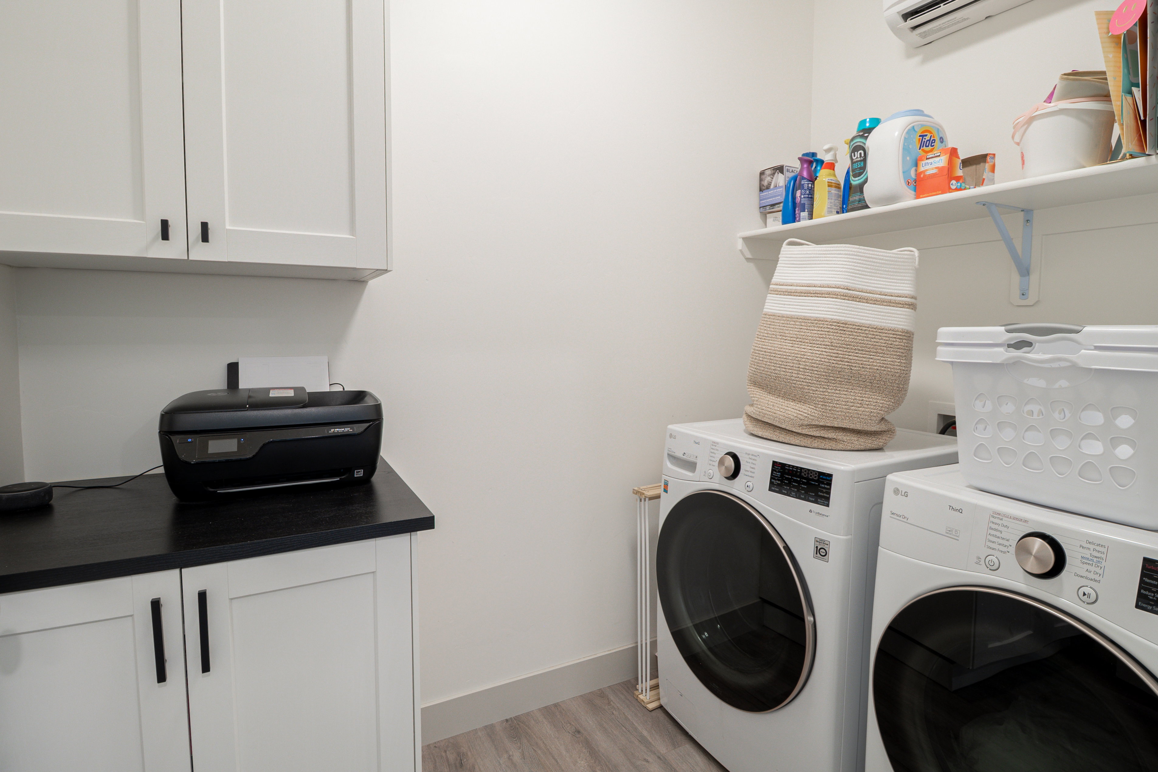 Laundry area featuring light wood-style floors, independent washer and dryer, and cabinet space