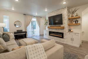 Living area featuring a fireplace, dark wood-type flooring, plenty of natural light, and recessed lighting