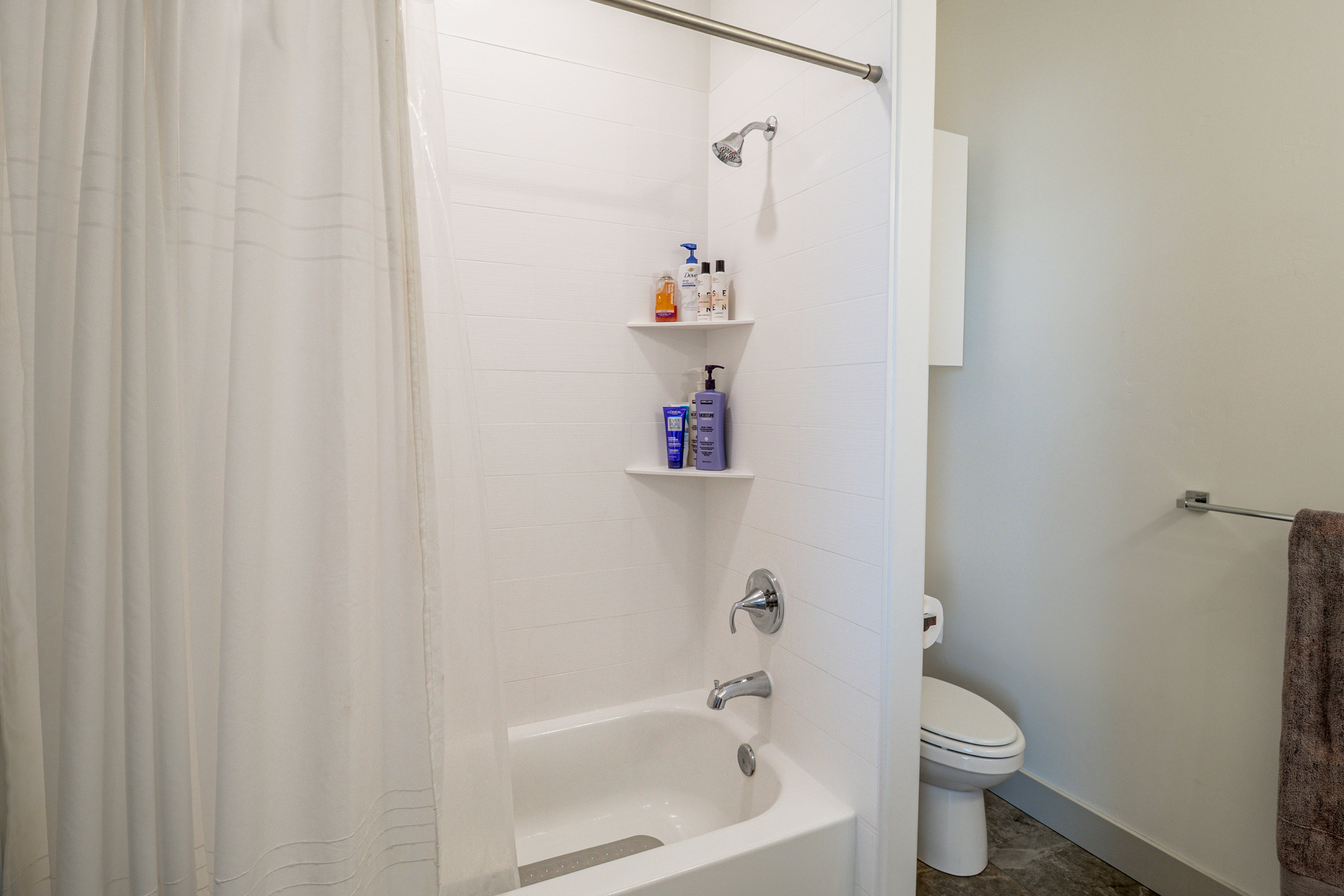 Bathroom with toilet and shower / bathtub combination with curtain