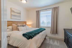 Bedroom featuring baseboards and light colored carpet