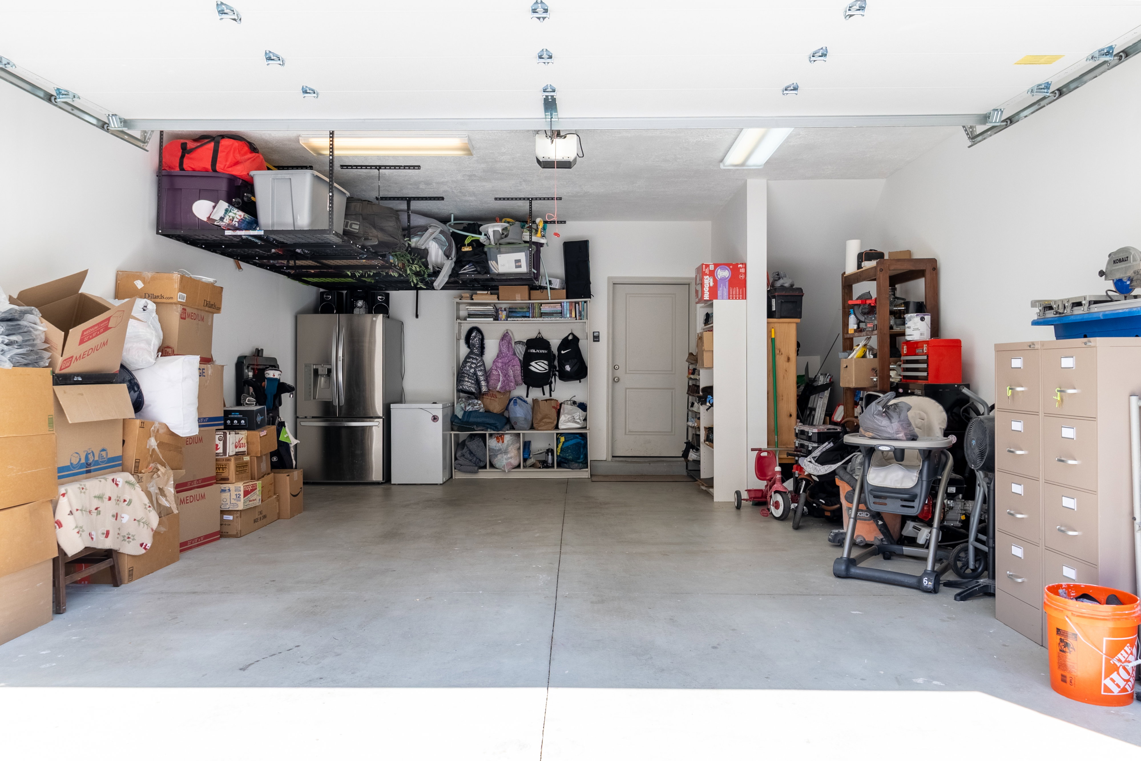 Garage featuring stainless steel fridge and white refrigerator