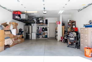 Garage featuring stainless steel fridge and white refrigerator