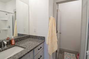 Full bath with a shower stall and vanity