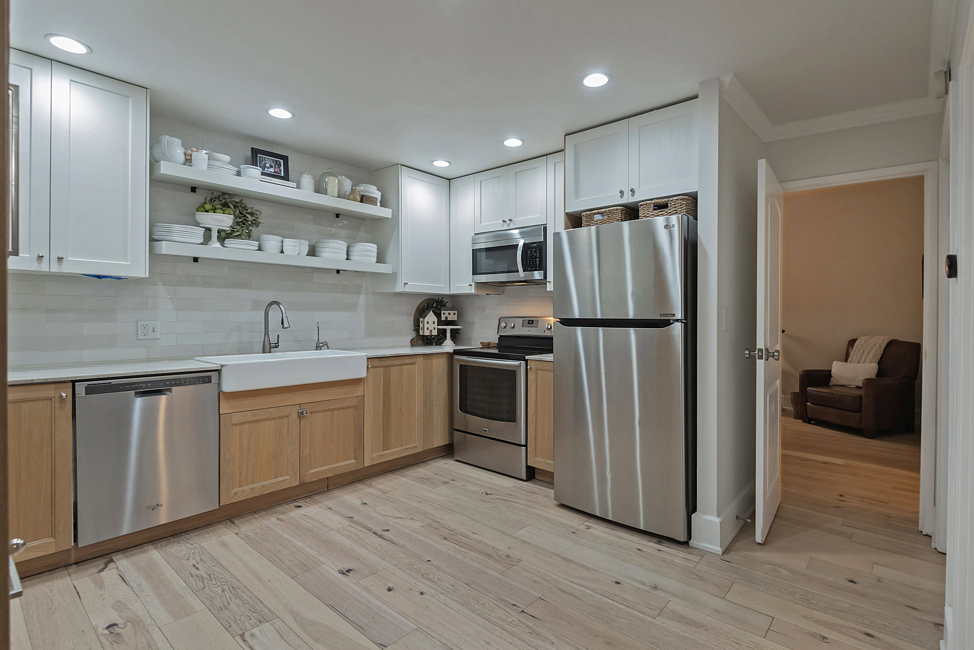 Kitchen with stainless steel appliances, open shelves, recessed lighting, backsplash, and light wood finished floors