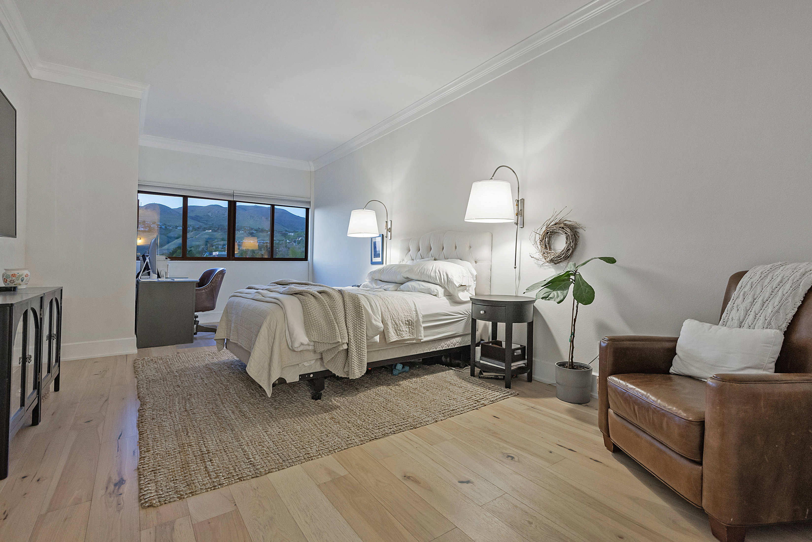 Bedroom featuring light wood-style flooring, crown molding, and a mountain view