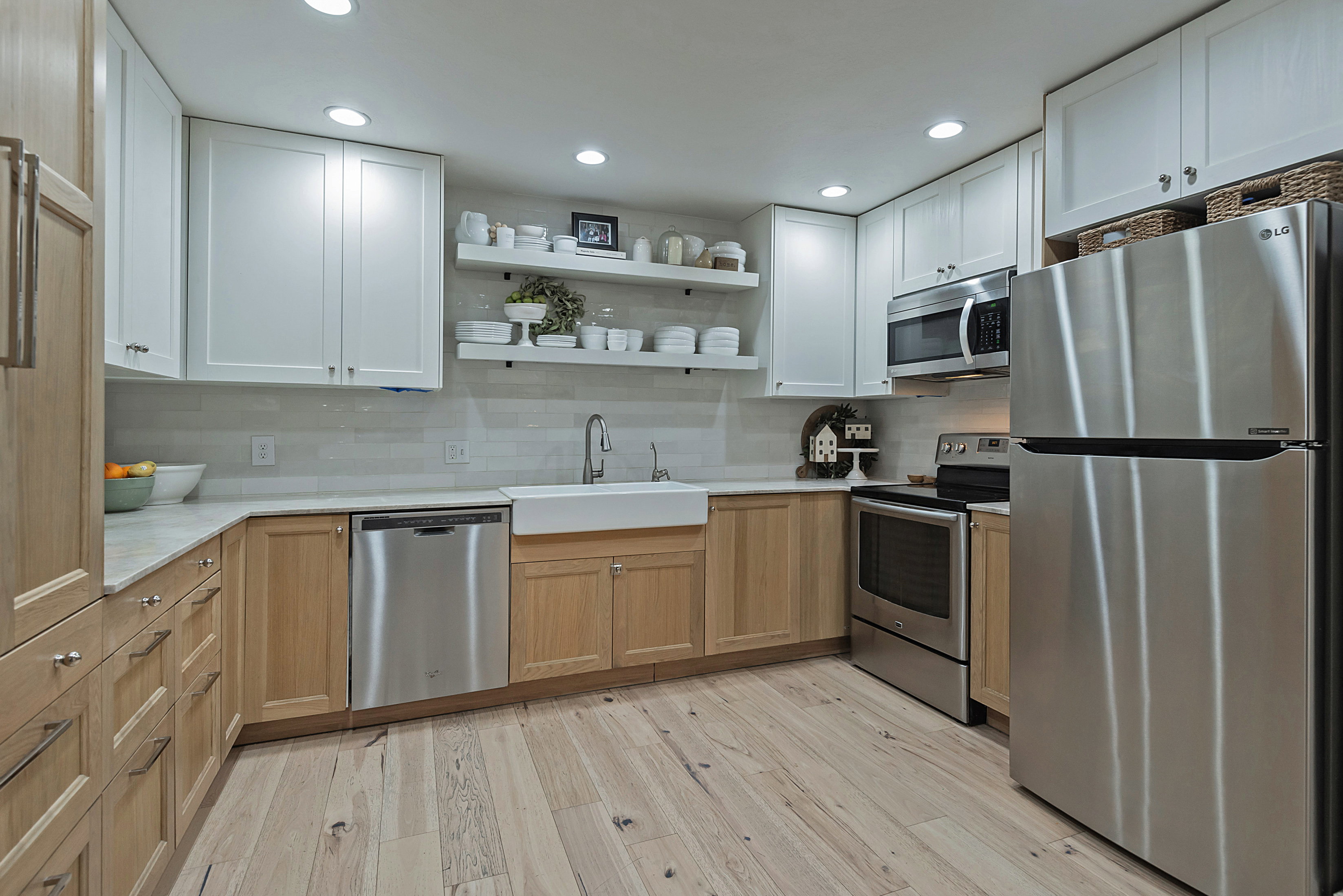 Kitchen with stainless steel appliances, open shelves, light wood finished floors, recessed lighting, and tasteful backsplash