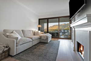 Living area featuring a tile fireplace, light wood-style floors, and crown molding