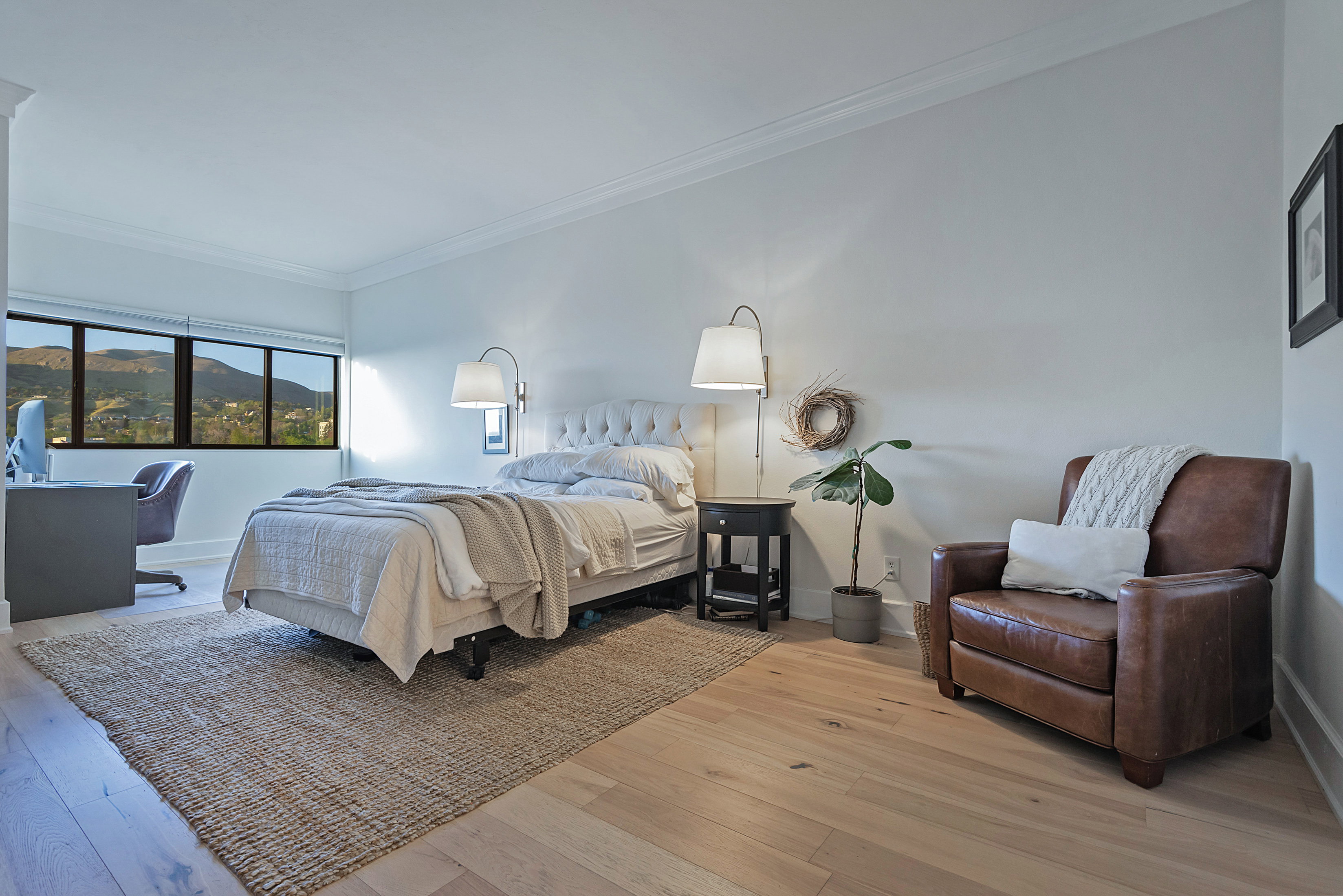 Bedroom with light wood-style floors, a mountain view, and ornamental molding