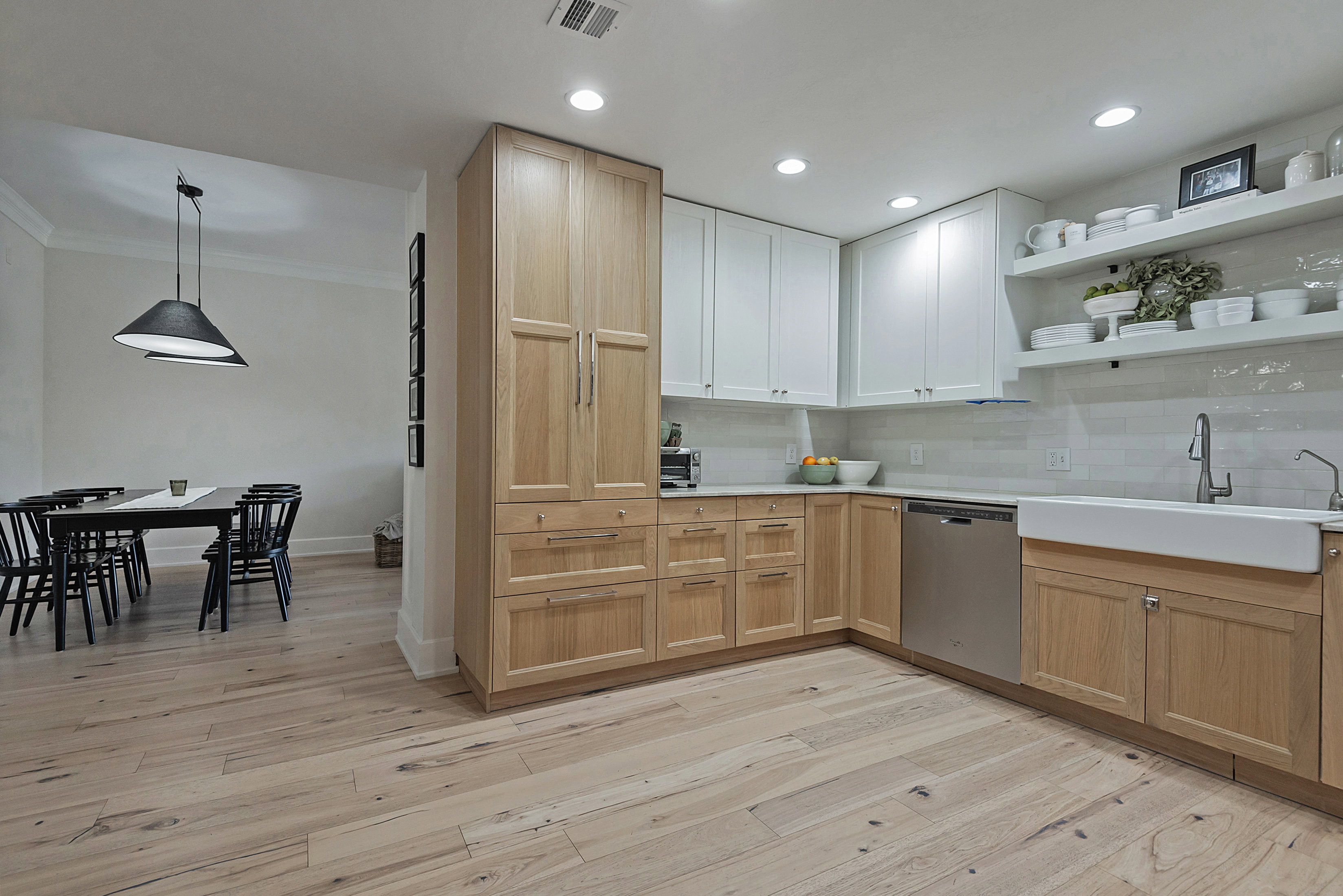 Kitchen with light wood-type flooring, tasteful backsplash, open shelves, dishwasher, and ornamental molding