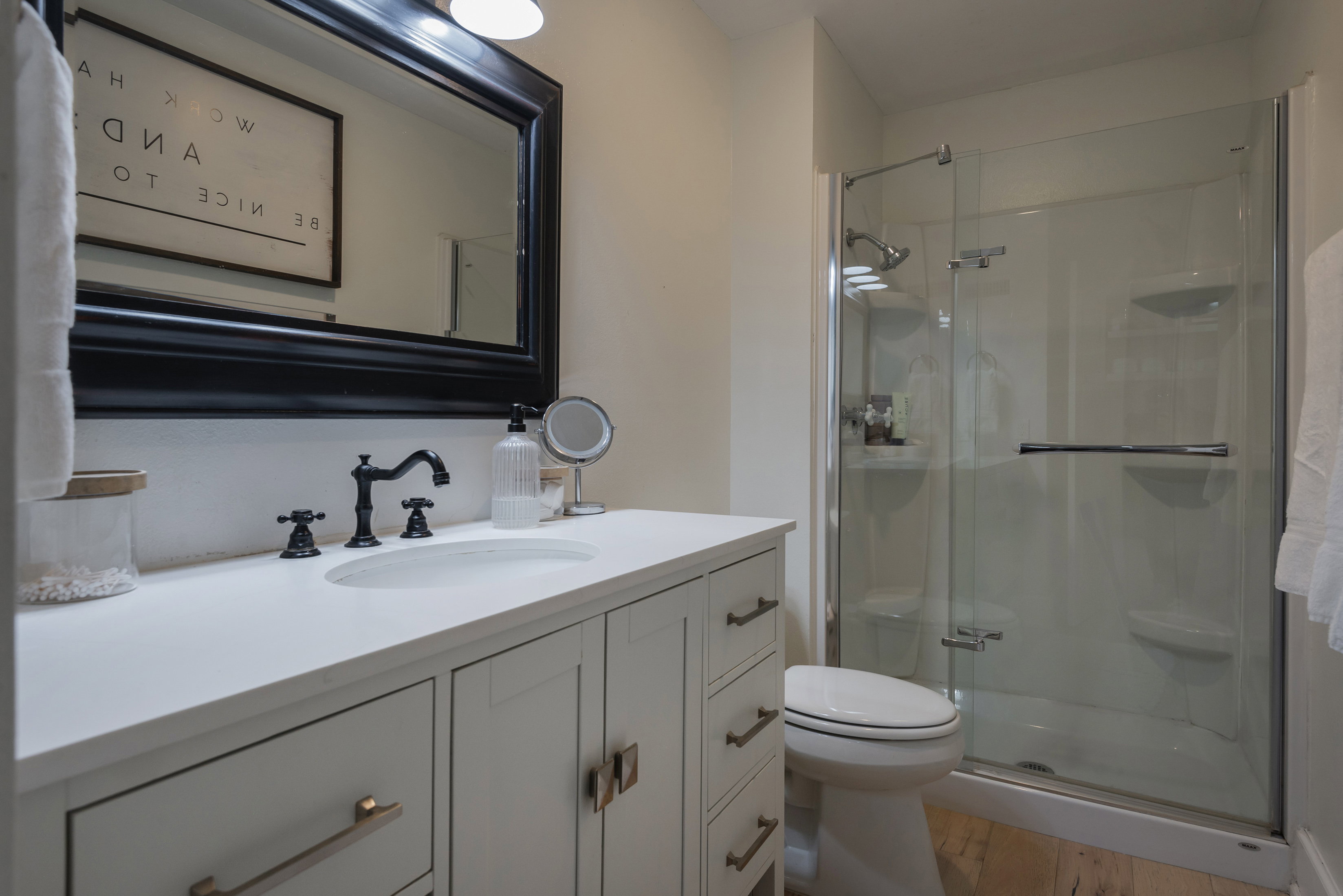 Full bathroom with vanity, a stall shower, and light wood-style flooring