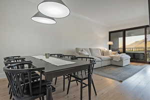 Dining space with light wood-style flooring and ornamental molding