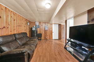 Living room with wood walls and light wood-style floors