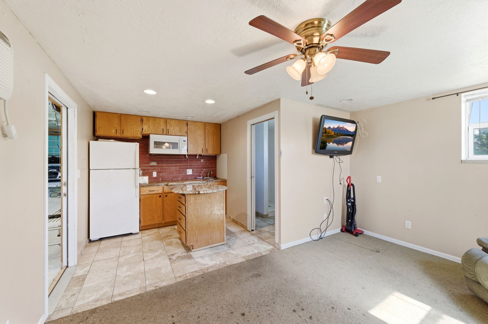 Kitchen with white appliances, light colored carpet, ceiling fan, recessed lighting, and wood finish cabinetry