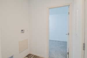 Laundry area featuring hookup for a washing machine, light carpet, and light wood finished floors