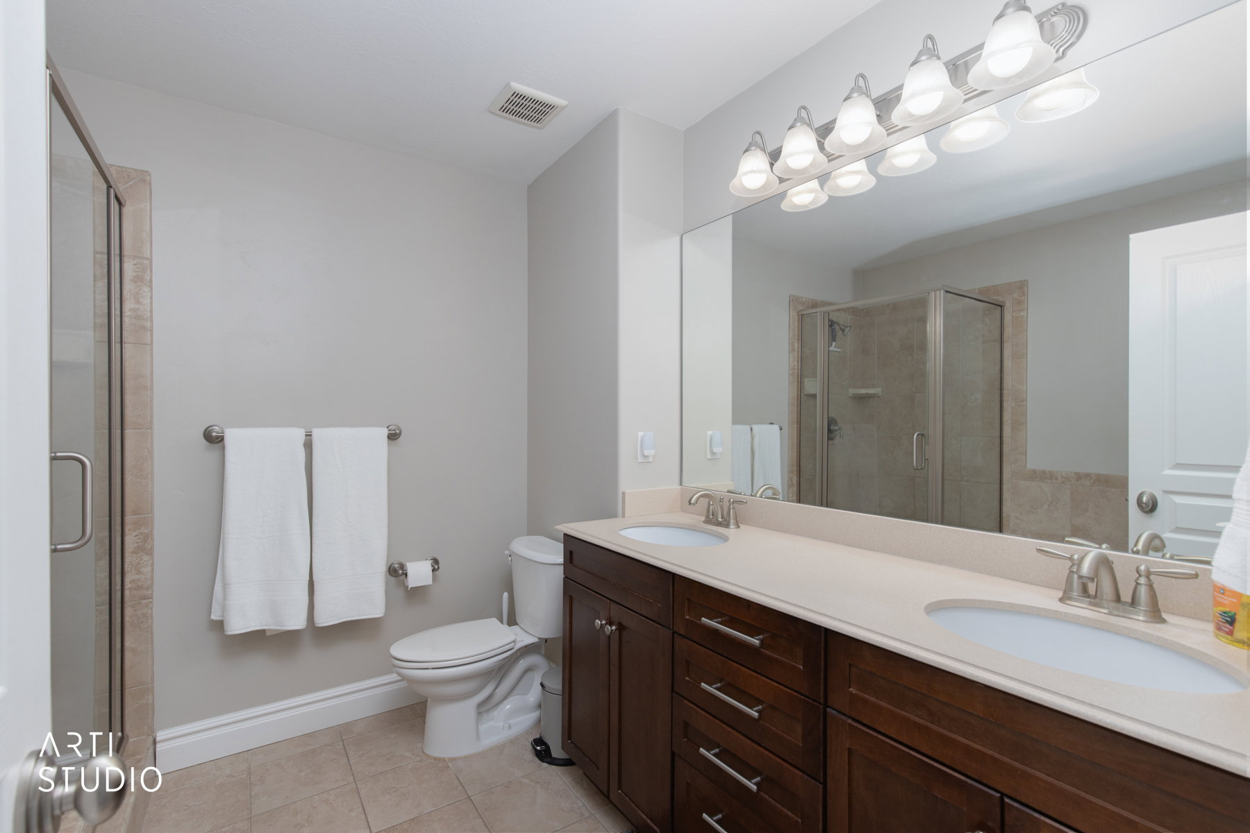 Primary bathroom with double vanity, light tile patterned floors, shower stall, and soaker tub